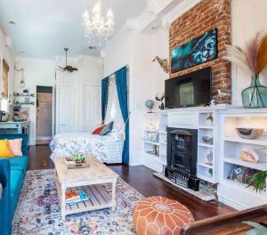 a living room with a couch and a fireplace at Historic Victorian Studio Near City Park NOMA Bayou St John in New Orleans
