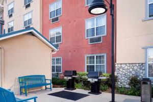 a building with a bench and two bbq grills at TownePlace Suites Los Angeles LAX Manhattan Beach in Hawthorne