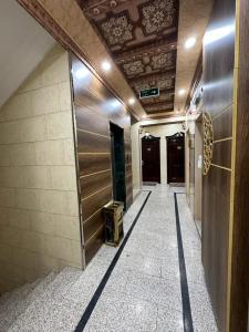 a hallway of a building with a door and a tile floor at شموع المروج للوحدات الفندقية in Tabuk