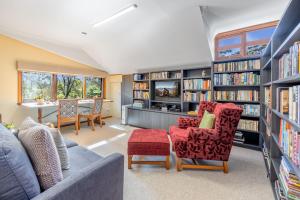 a living room with a couch and chairs and bookshelves at Sieberi Escape in Katoomba