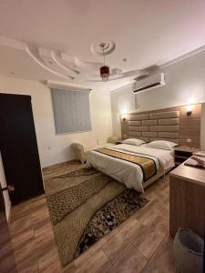 a bedroom with a large bed and a rug at شموع المروج للوحدات الفندقية in Tabuk