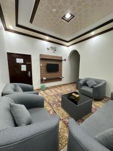 a living room with two couches and a flat screen tv at شموع المروج للوحدات الفندقية in Tabuk