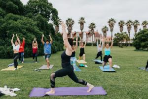 a group of people doing yoga in a park at Gijon Surf Hostel in Gijón