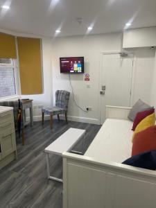 a hospital room with a bed and a tv on the wall at EAST LONDON APARTMENTS SELF check in in London