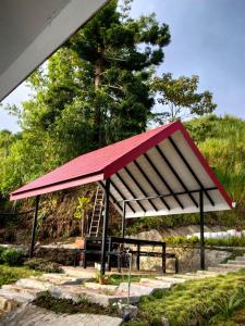 a picnic shelter with a red and white roof at KUNDASANG MOUNT GARDEN in Kundasang