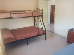 a room with two bunk beds in a room at Triple N Homestay Beachfront House in Lobo in Lobo