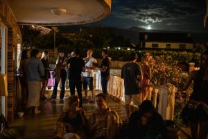 a group of people standing on a deck at night at Gijon Surf Hostel in Gijón