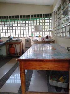 a kitchen with a table in a room with windows at Triple N Homestay Beachfront House in Lobo in Lobo