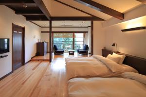 a bedroom with two beds and a television in a room at Kasuga Hotel in Nara