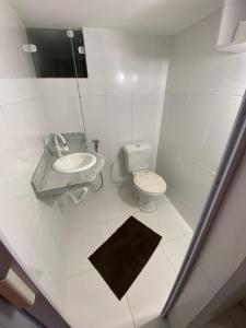 a white bathroom with a toilet and a sink at THE BROTHERS in Angra dos Reis