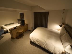 a hotel room with a bed and a desk with a television at Hotel Resol Stay Akihabara in Tokyo