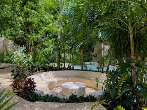 une piscine au milieu d'un jardin arboré dans l'établissement Syrena Luxury Caribbean, à Playa del Carmen