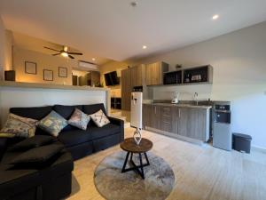 a living room with a black couch and a kitchen at Syrena Luxury Caribbean in Playa del Carmen