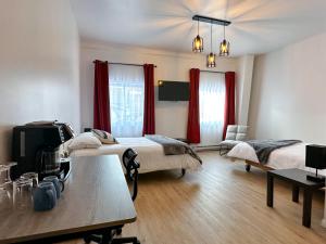 two beds in a room with red curtains at OTIS Nature in Lamarche