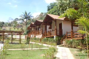 a resort building with wooden balconies and a garden at POUSADA SuaCasita - 5 LAGOS in Mairiporã