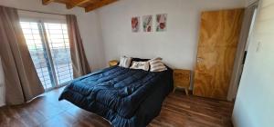 1 dormitorio con 1 cama con manta azul en Departamento Montecaseros San Rafael - Factura A - en San Rafael