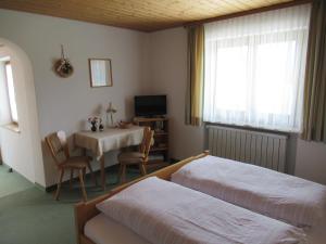 a bedroom with two beds and a table and a television at Haus Elfriede in Reit im Winkl