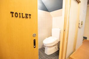 een badkamer met een toilet en een deur met het woord toilet bij Guest House POST INN in Tenkawa