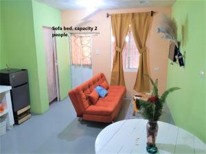 een woonkamer met een oranje bank en een tafel bij COMFY furnished private apartment.Netflix/internet in Chimaltenango