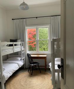 1 dormitorio con literas, escritorio y ventana en The Country House Maffra, en Maffra