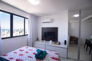 Dieses weiße Zimmer verfügt über ein Bett, einen TV und ein Zimmer. in der Unterkunft Flat lado Shopping -Vista p Mar in Recife