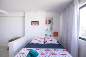 ein weißes Schlafzimmer mit einem Bett mit roten und blauen Kissen in der Unterkunft Flat lado Shopping -Vista p Mar in Recife