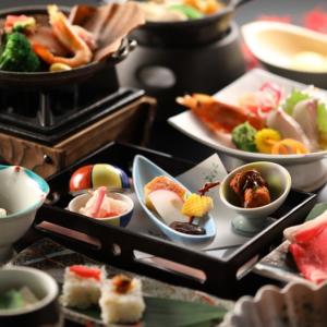 a table with plates of sushi and other food at Hotel Kameya Honten in Chikuma