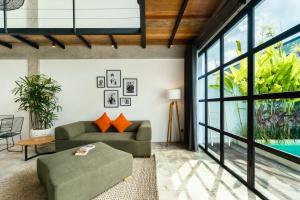 a living room with a couch and a table at Berawa Lofts #2 Canggu in Canggu +26 photos
