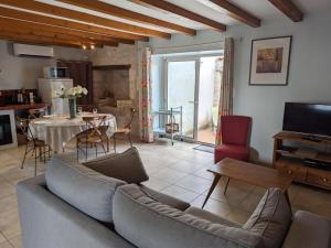 salon z kanapą i stołem w obiekcie Maison de Charme avec Jardin, Proche La Rochefoucauld, Wifi, Ping-Pong, et Equipement Bébé - FR-1-653-35 w mieście Bunzac