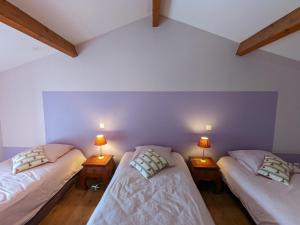 2 łóżka pojedyncze w pokoju z 2 lampami w obiekcie Maison de Charme avec Jardin, Proche La Rochefoucauld, Wifi, Ping-Pong, et Equipement Bébé - FR-1-653-35 w mieście Bunzac