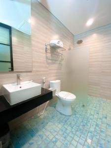 a bathroom with a white toilet and a sink at Swiss-Belexpress Rest Area KM. 19 Cikampek in Cikunir Satu