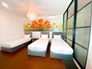 two beds in a room with a painting on the wall at Swiss-Belexpress Rest Area KM. 19 Cikampek in Cikunir Satu