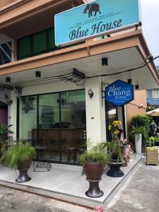 ein blaues Haus mit Topfpflanzen vor einem Geschäft in der Unterkunft Blue Chang House in Bangkok