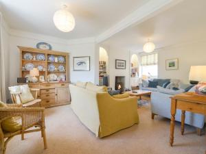 ein Wohnzimmer mit Sofa, Stühlen und einem Tisch in der Unterkunft 4 Coastguards Cottage in Hope-Cove