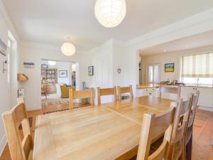 eine Küche und ein Esszimmer mit einem Holztisch und Stühlen in der Unterkunft 4 Coastguards Cottage in Hope-Cove