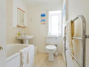 ein weißes Badezimmer mit Toilette und Waschbecken in der Unterkunft 4 Coastguards Cottage in Hope-Cove + 23 Fotos
