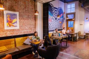 a group of people sitting at tables in a restaurant at YHA Melbourne Central in Melbourne