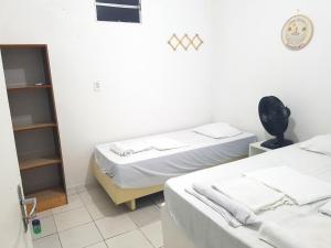a room with two beds and a mirror at Casa Brisa in Fortaleza