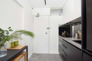 シドニーにあるSunny & peaceful apartment in Sydney - Rushcutters bayの白い壁と白いカウンター付きのキッチン