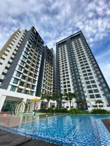 dos edificios altos con una piscina frente a ellos en RUMA Executive Homestay Bukit Mertajam with Pool Netflix #FREETAX en Bukit Mertajam