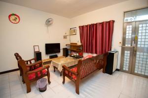 a living room with a couch and a table and a television at Green Close House Homestay in Yuanshan