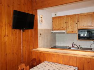 eine Küche mit Holzschränken und einem TV an der Wand in der Unterkunft Studio Tignes, 1 pièce, 4 personnes - FR-1-502-515 in Tignes