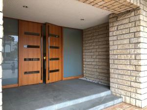 parę drewnianych drzwi na murze w obiekcie Alphabed Fukuyama Nishi Sakura Machi 205 / Vacation STAY 22290 w mieście Fukuyama