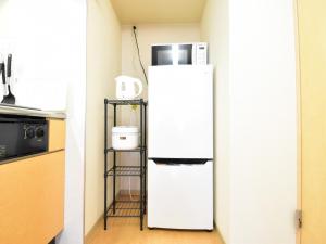 um frigorífico branco numa cozinha com um micro-ondas em Alphabed Fukuyama Nishi Sakura Machi 205 / Vacation STAY 22290 em Fukuyama
