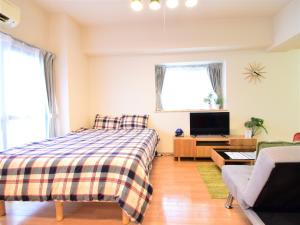 a bedroom with a bed and a tv and a couch at Alphabed Fukuyama Nishi Sakura Machi 205 / Vacation STAY 22290 in Fukuyama