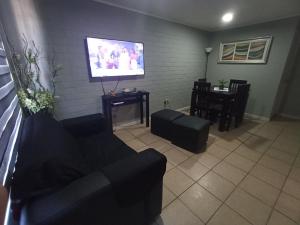 a living room with a couch and a flat screen tv at Hostal JV QUILLOTA AMOBLADA in Quillota