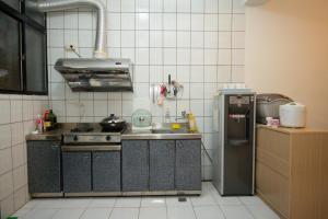 a small kitchen with a stove and a refrigerator at Green Close House Homestay in Yuanshan