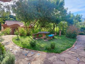 una mesa de picnic y un banco en un jardín en YVY CASA HOTEL en Samaipata