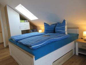 Mücheln的住宿－Seehaus Maria mit Wassergrundstück，一间卧室配有蓝色的床和蓝色枕头