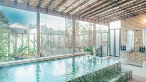 a swimming pool in a building with a large window at Kuretake-Inn Fujisan in Fuji